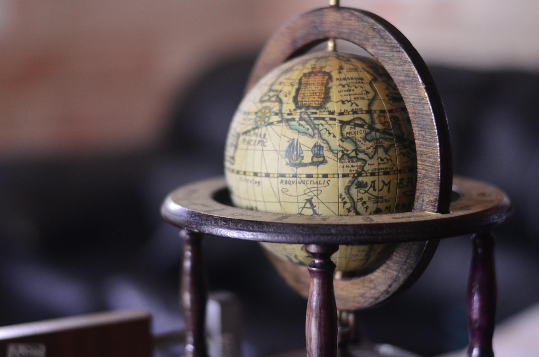 Close-up of a vintage wooden globe with antique map design, highlighting exploration themes.